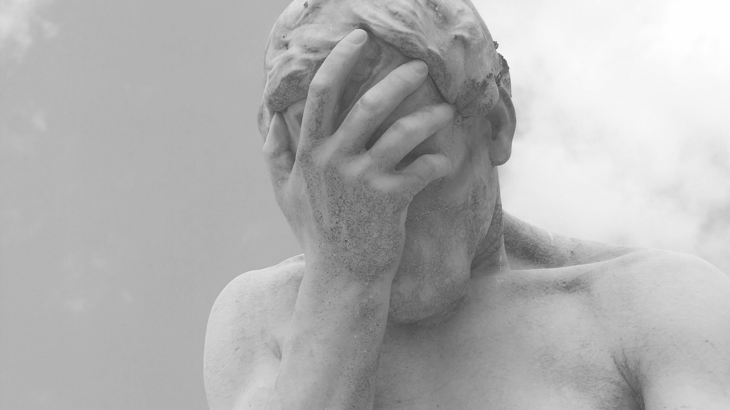 posąg z ręką na twarzy